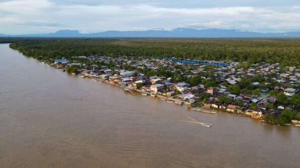 Serene aerial view of Vigia Del Fuerte village along a river in Colombia, surrounded by lush greenery.
